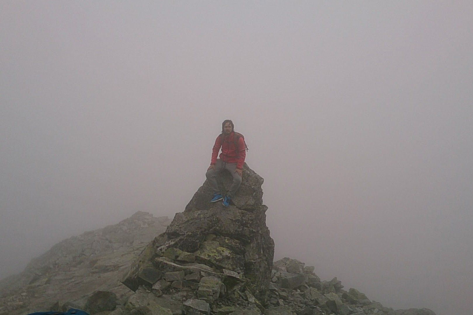 A Hiker Sitting At The Top Of Rysy