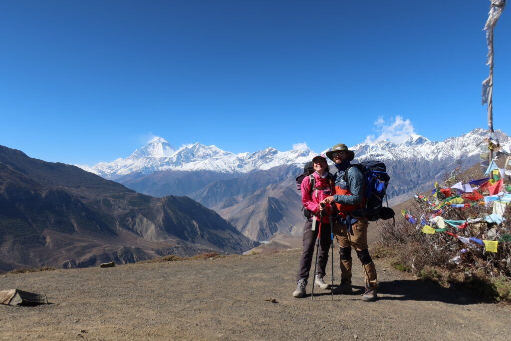 Two hikers with mountain peaks in the background in Nepal on Annapurna Circuit trail